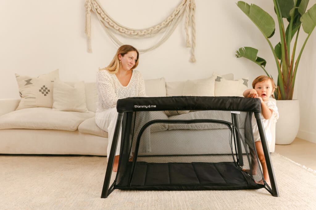mom and baby in a lightweight travel crib in a sunlit hotel room