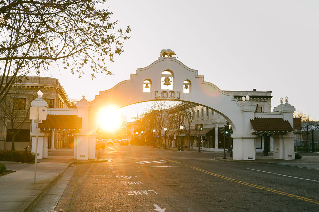 lodi california at sunset with light peaking through the archway bell downtown tourism board