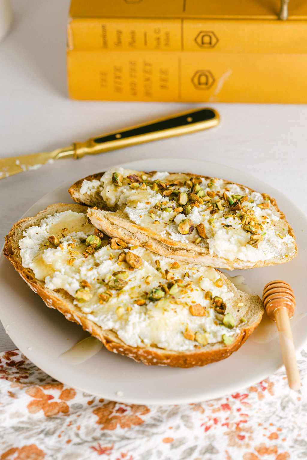 Lifestyle cozy boho cottage breakfast toast with ricotta honey pistachio and books in the kitchen