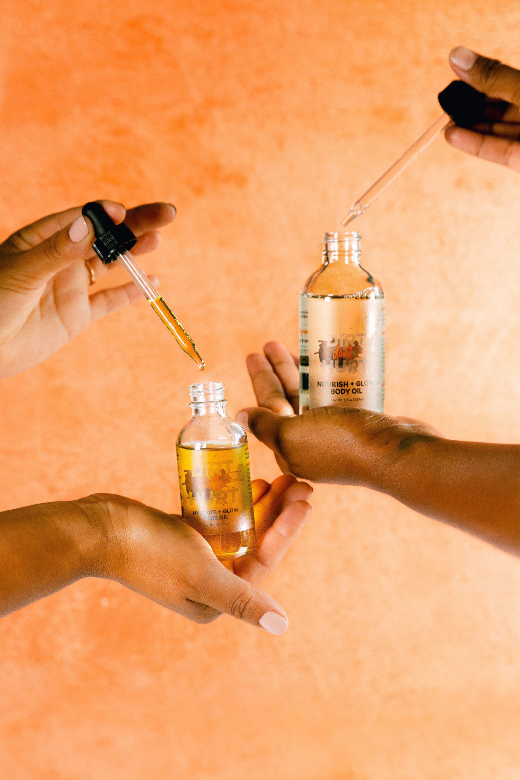 Styled skincare product photography body oils in hands using droppers black owned small business