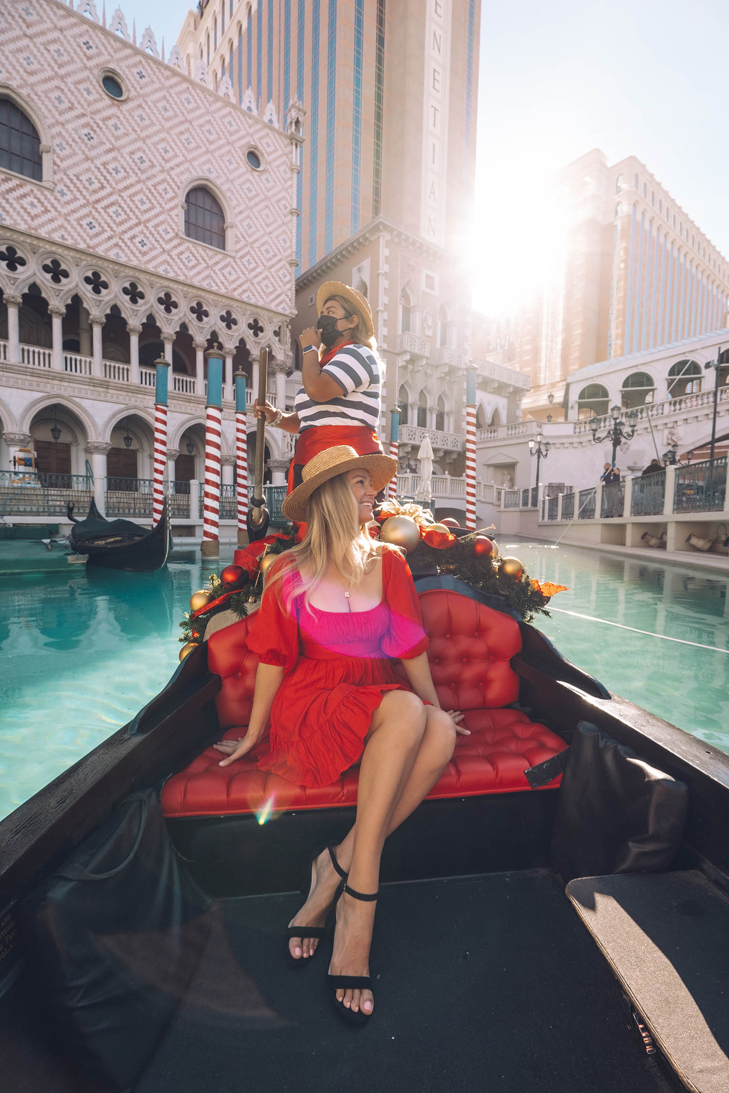 Girl in red dress in gondola at The Venetian in Las Vegas. The Blonde Abroad for Travel & Leisure magazine by Chelsea Loren.