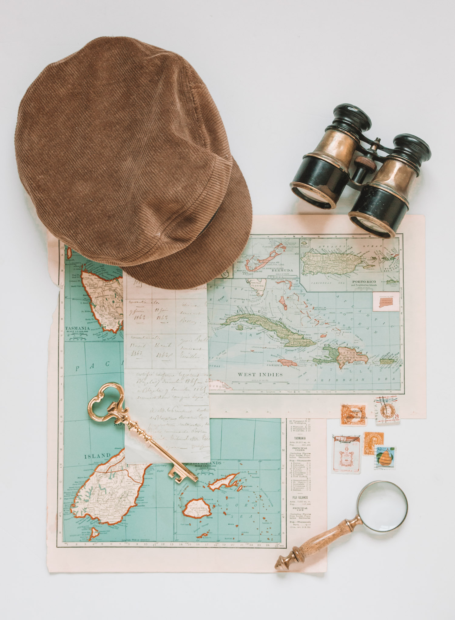 Vintage travel flat lay with hat key magnifying glass binoculars by Chelsea Loren flat lay photographer