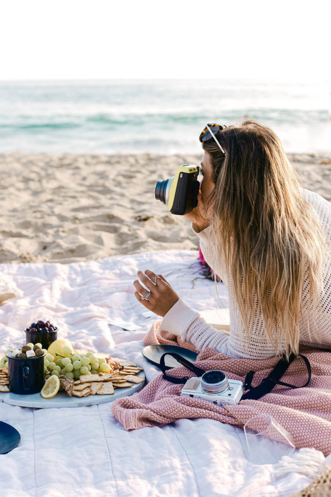 Beach picnic with cameras charcuterie and pizza by branding photographer Chelsea Loren