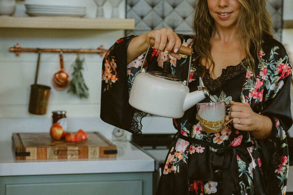 woman in robe pouring coffee and making breakfast at airbnb cabin