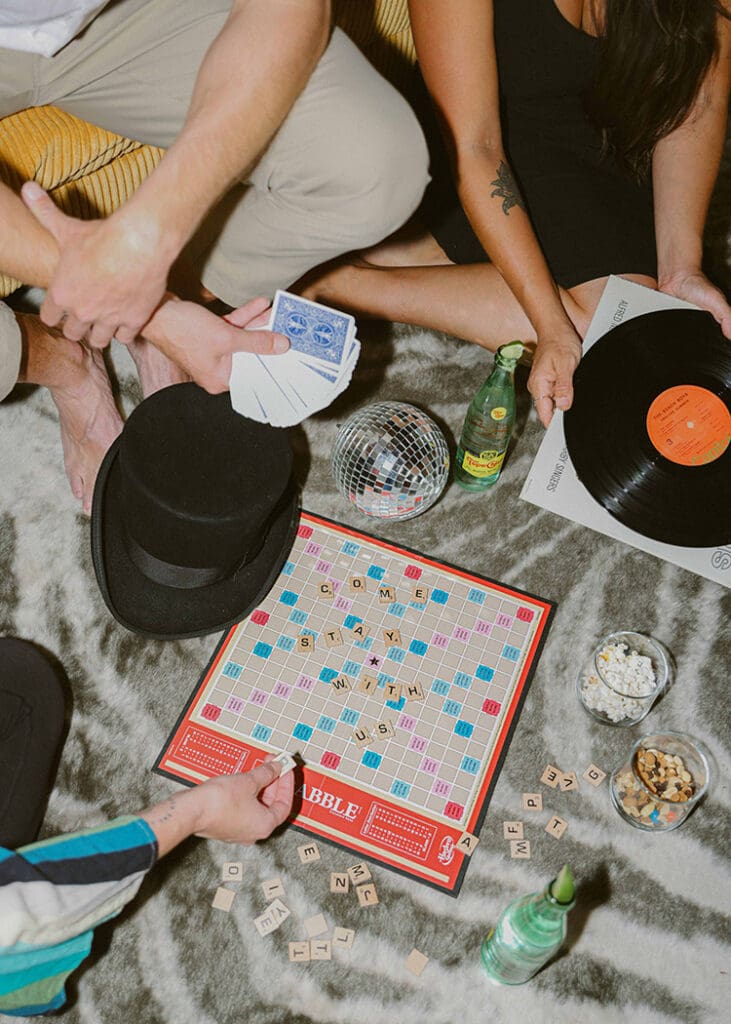 group of friends playing board games and scrabble with records disco ball for lifestyle airbnb photography