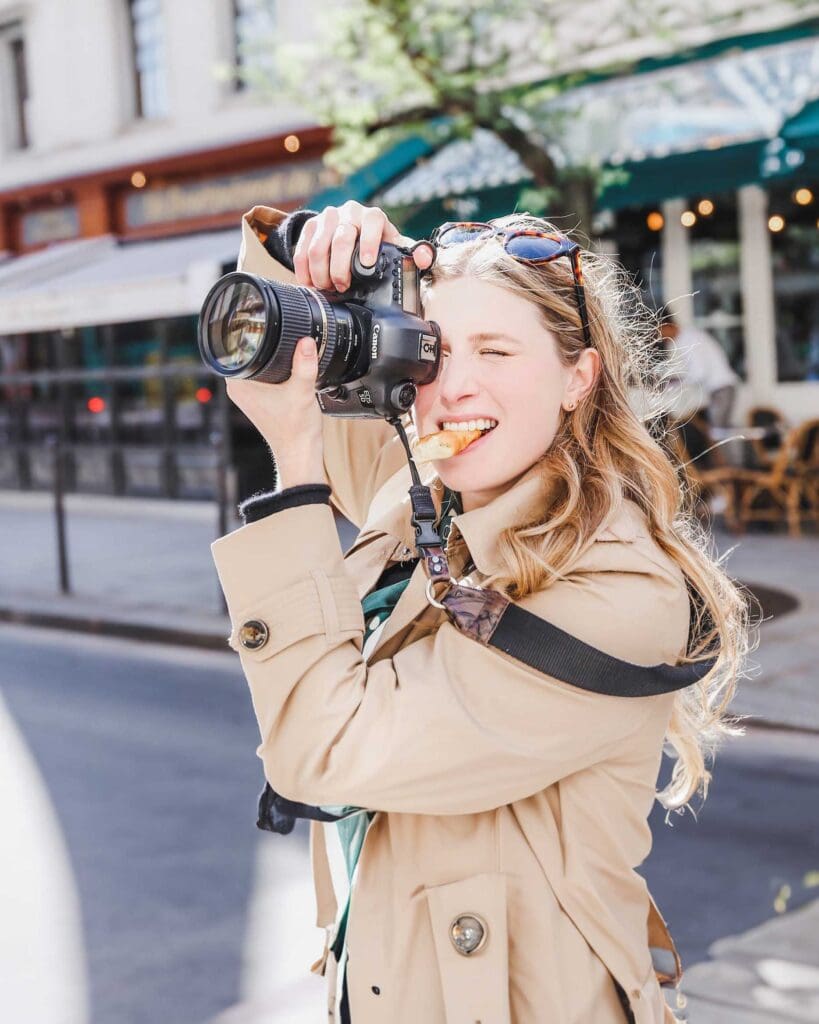 Girl Eating Croissant Paris with Camera Trench Coat