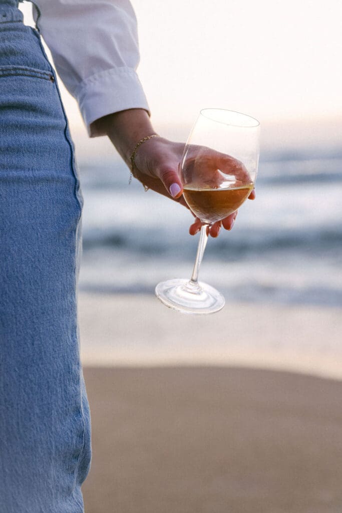 girl drinking glass of wine on beach monterey california - boutique hotel photography