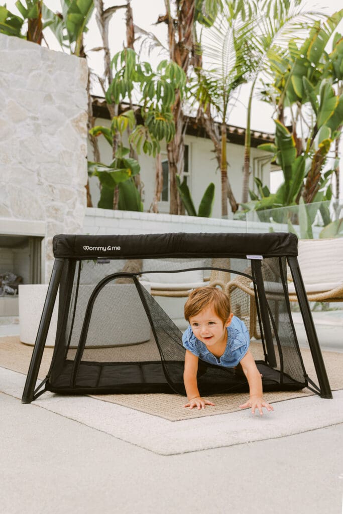 baby crawling out of travel crib with side zipper luxury commercial kids lifestyle photography