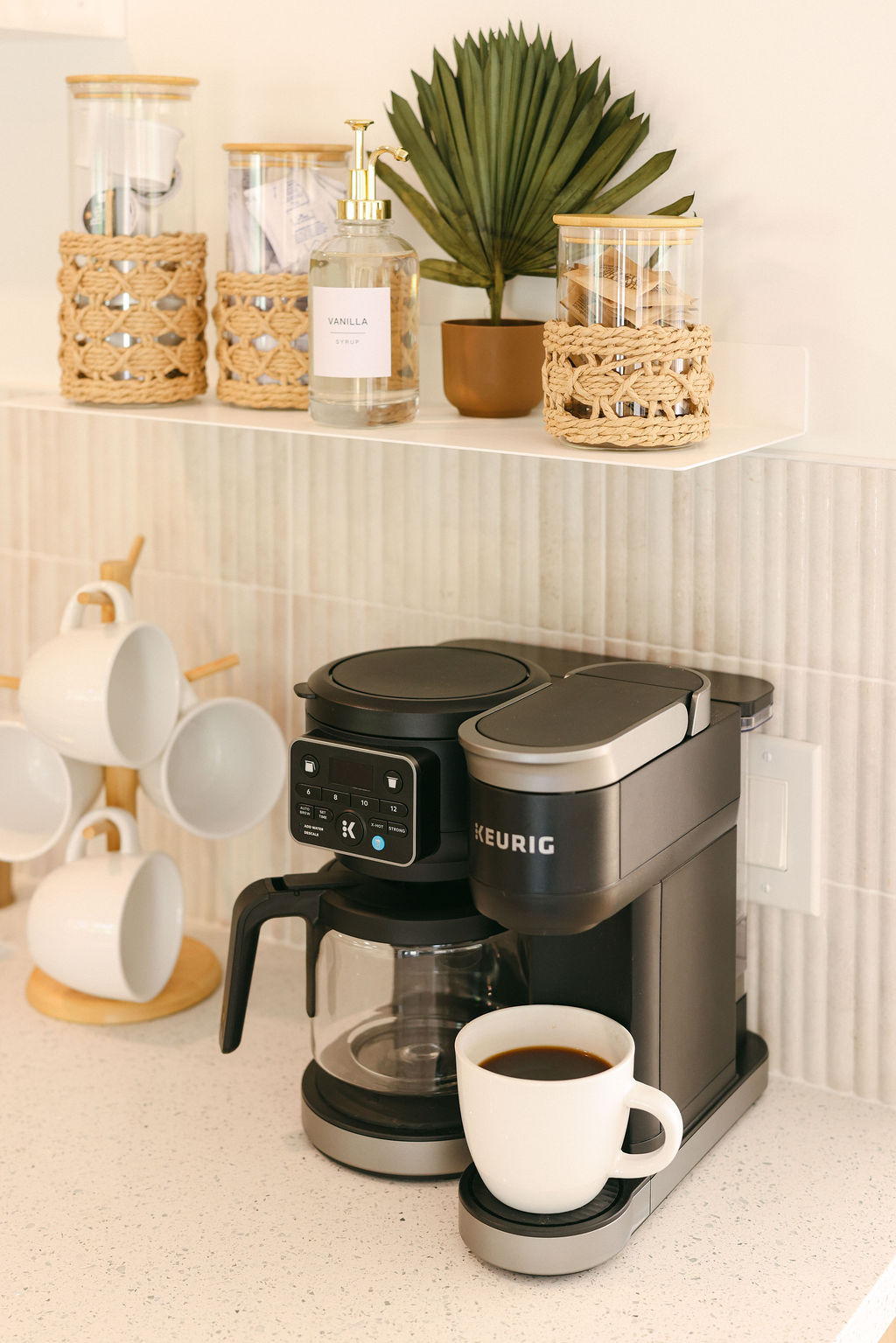Luxury Airbnb outdoor deck with teak lounge furniture, woven rattan lanterns, tropical banana plant, and direct Carlsbad Lagoon waterfront views in Southern California, photographed by Chelsea Loren