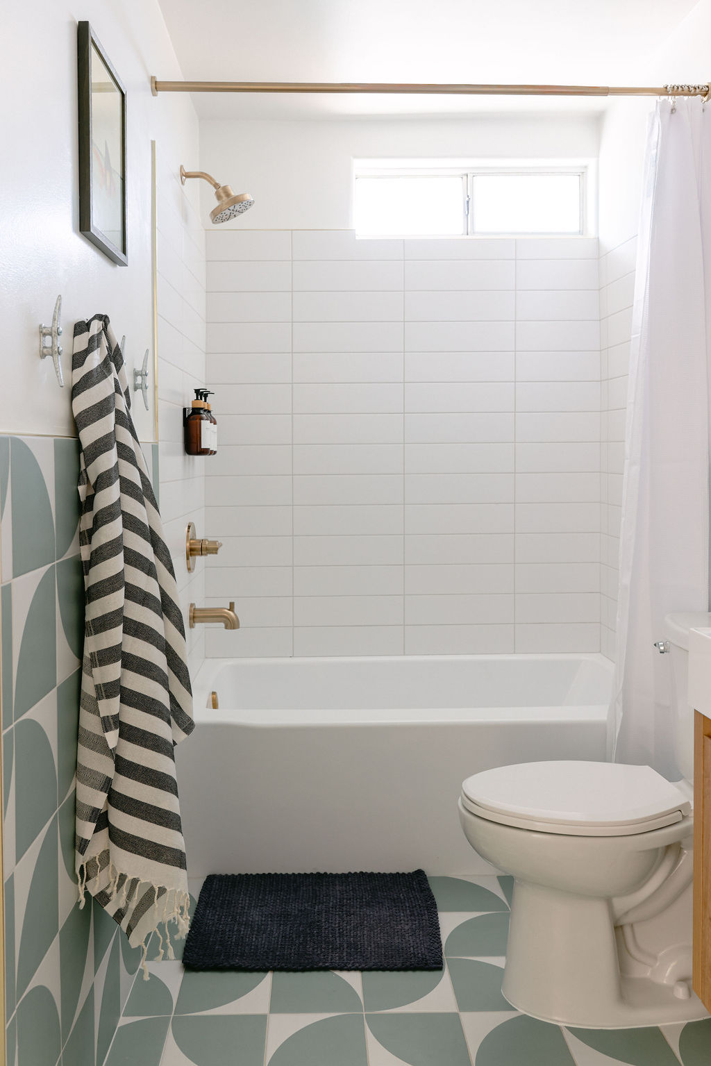 Luxury Airbnb dining area with marble pedestal table, wood and rattan chairs, and large framed coastal whale artwork in Carlsbad, California, photographed by Chelsea Loren