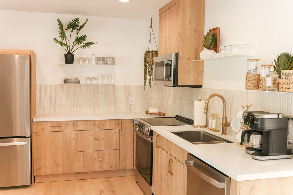 Luxury Airbnb breakfast in bed with a wooden charcuterie board of pastries, berries, and coffee on crisp white linens in Carlsbad, California, photographed by Chelsea Loren