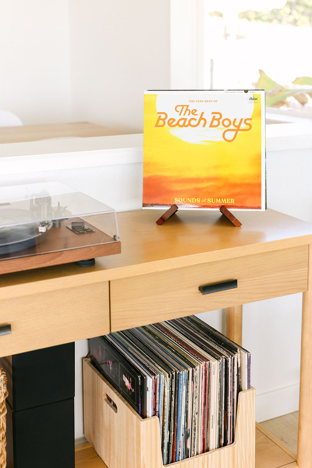 Beach Boys Sounds of Summer vinyl record displayed on a turntable console with a curated record collection at a luxury Airbnb in Carlsbad, California, photographed by Chelsea Loren