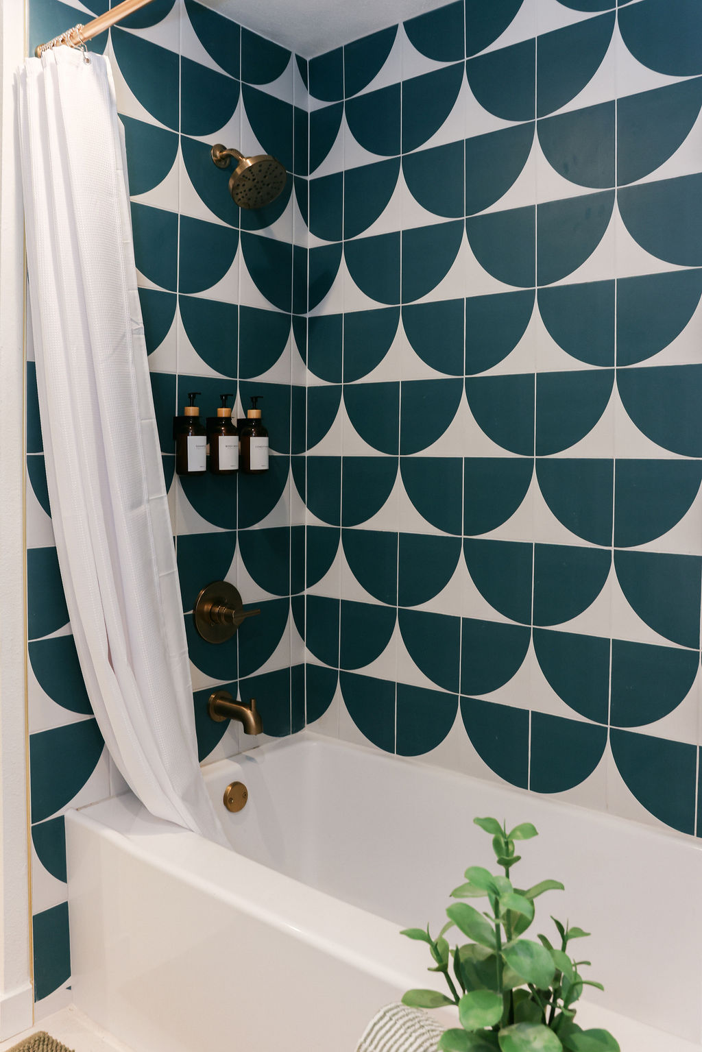 Teal scallop-tiled shower and soaking tub with brass fixtures and luxury bath products at a boutique Carlsbad Airbnb, photographed by Chelsea Loren