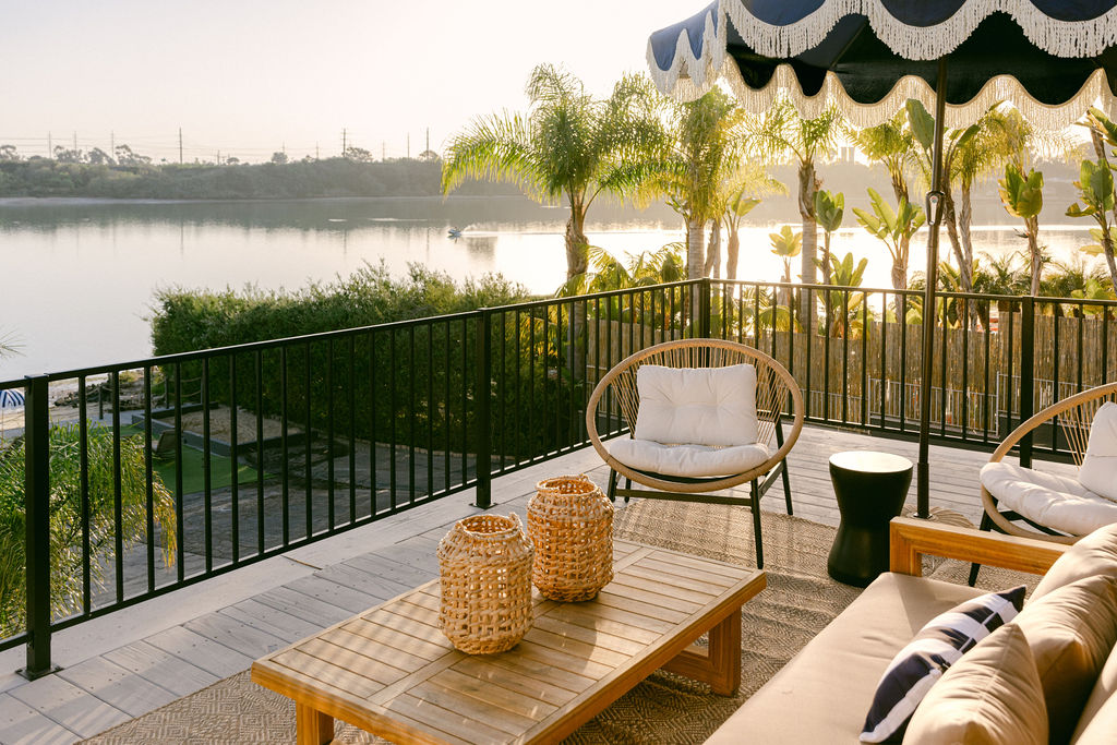 Luxury rooftop terrace with designer rattan furniture and panoramic lagoon views at a boutique Carlsbad Airbnb — strategic outdoor space photography for short-term rental owners in San Diego by Chelsea Loren