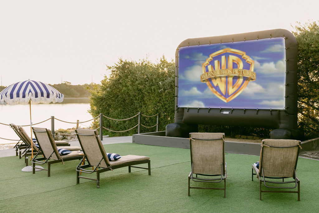Luxury outdoor cinema at a waterfront Carlsbad Airbnb, private inflatable movie screen with lounge chairs overlooking the lagoon, photographed by Chelsea Loren