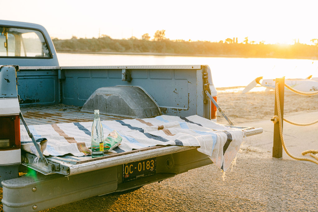 Styled vintage truck tailgate at golden hour on the Carlsbad lagoon, aspirational lifestyle photography for a luxury Southern California Airbnb brand shoot by Chelsea Loren