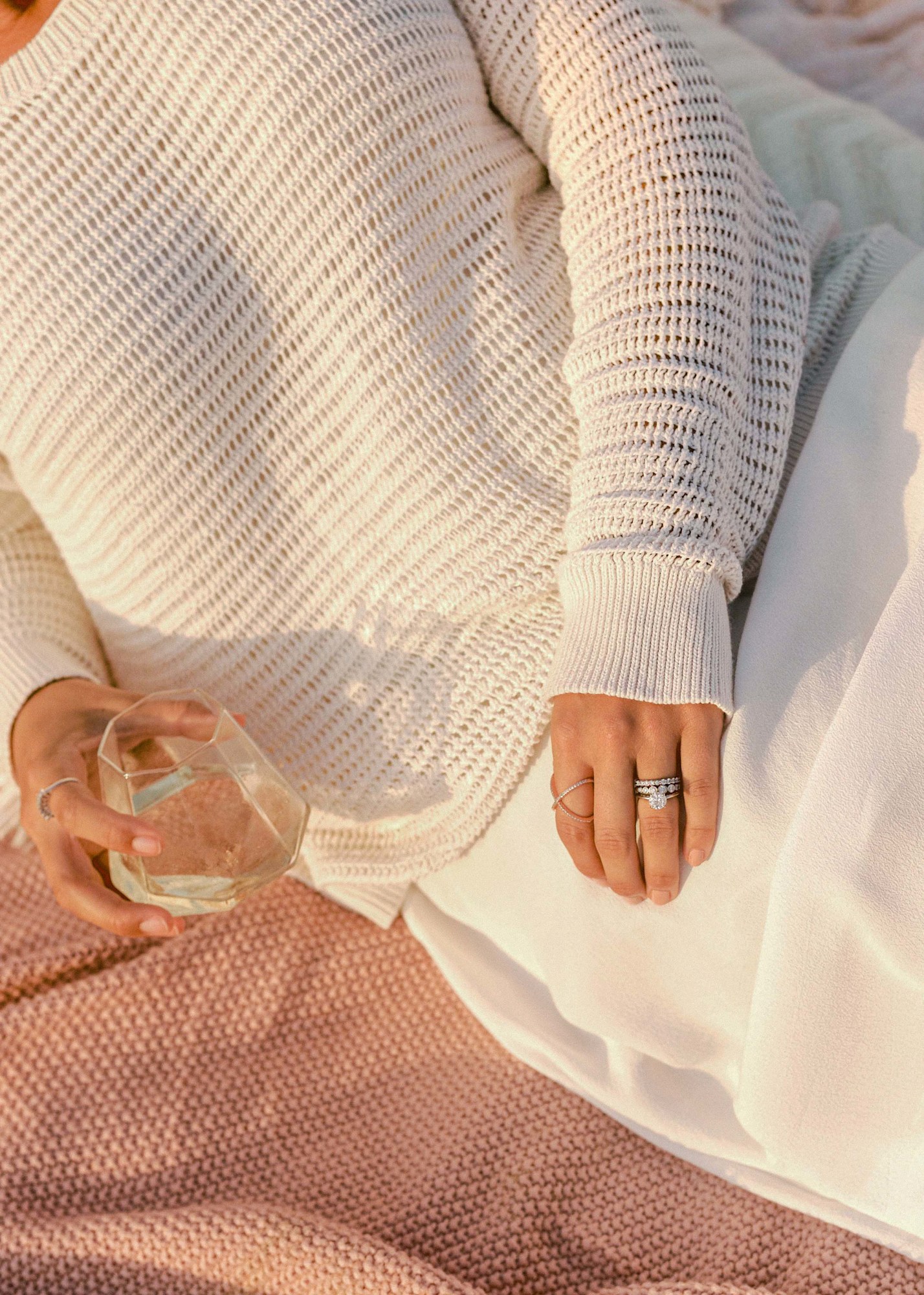 Fashion lookbook detail shot of knit sweater texture with rings and white skirt in golden light | Chelsea Loren Creative Director California