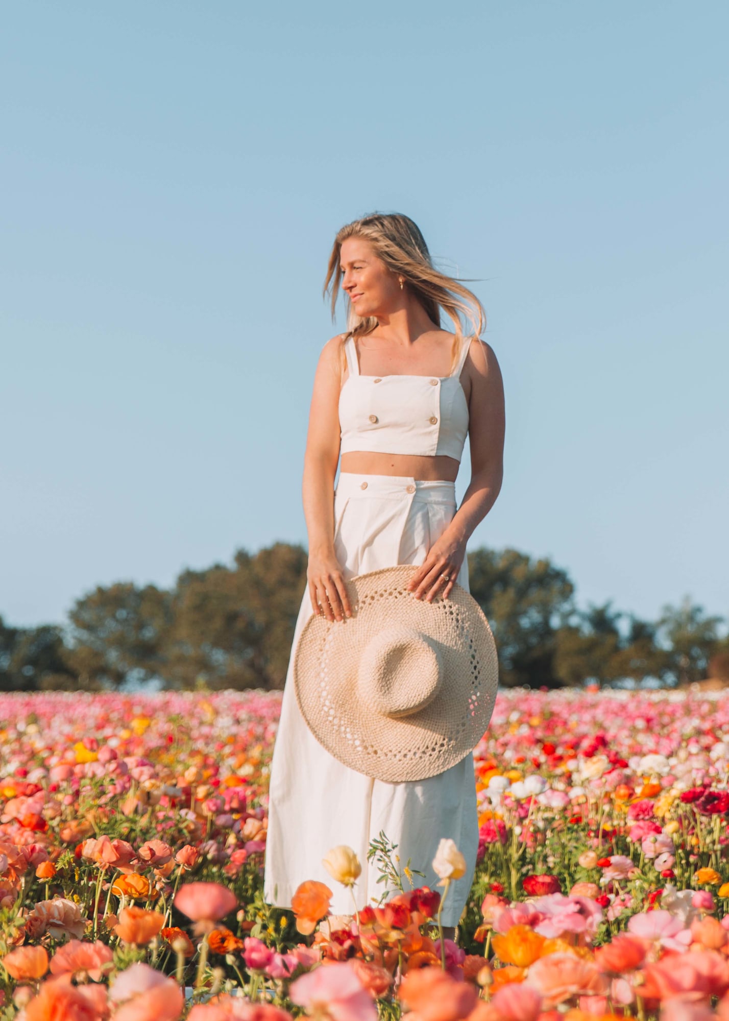 Woman in white linen set standing in California flower field with wind in hair for fashion lookbook | Chelsea Loren Photographer