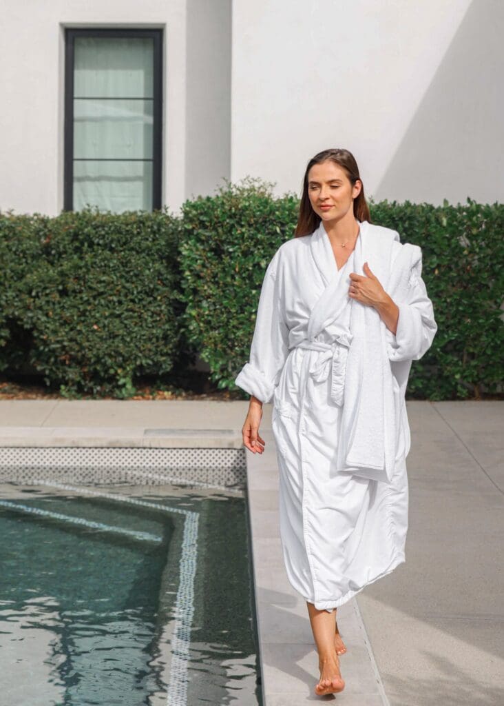 Fashion lookbook model in white robe walking poolside at modern California architecture | Chelsea Loren Creative Director Photographer