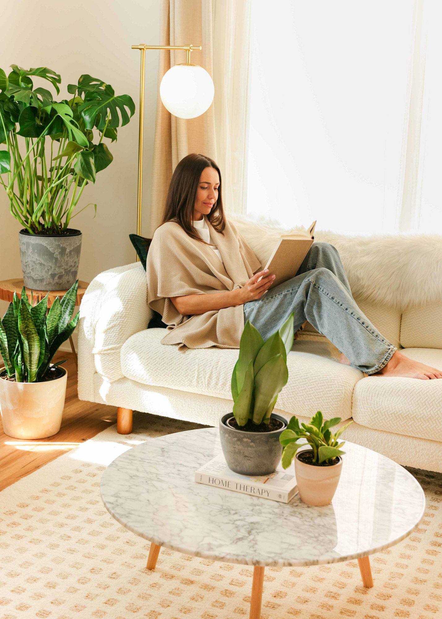 Woman reading on cream sofa in linen wrap with warm afternoon light and plants for lifestyle fashion lookbook | Chelsea Loren Photographer Creative Director