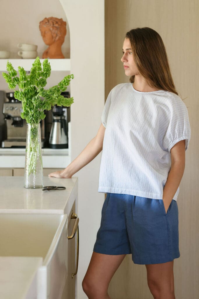 MUJI Spring Summer 2026 linen collection – model casually relaxed with coffee mug in warm interior setting, lifestyle brand photography by Chelsea Loren