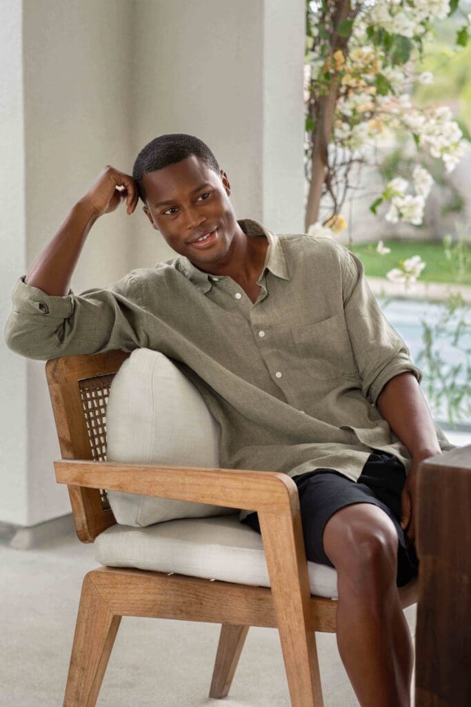 Model wearing MUJI sage linen shirt in relaxed natural light lifestyle photography