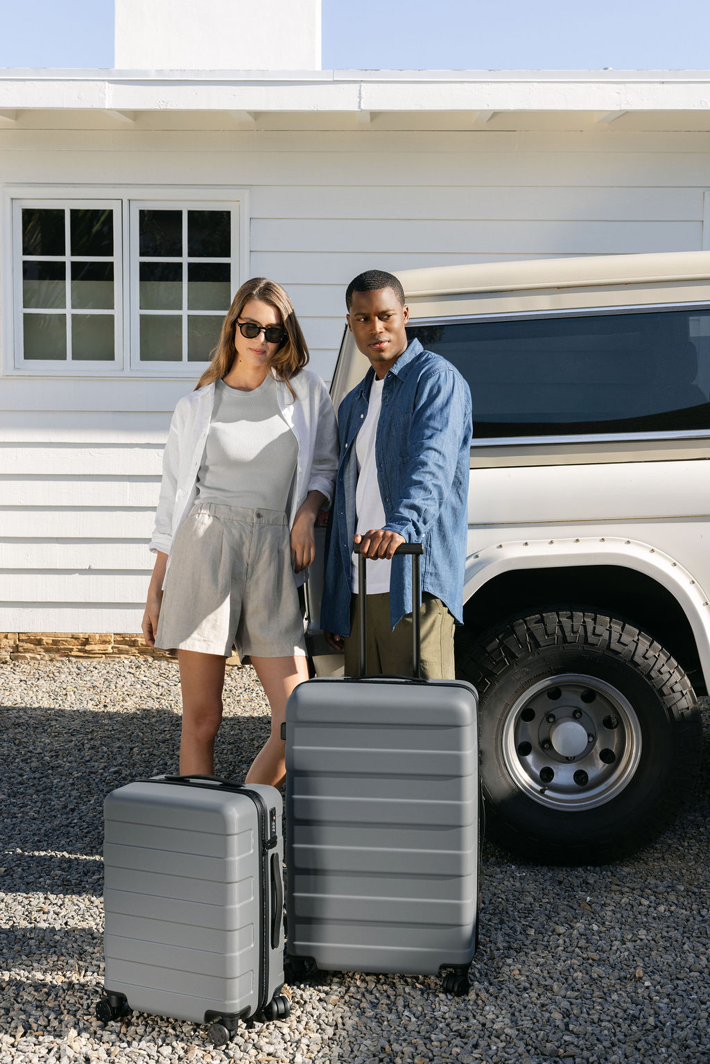 MUJI Spring Summer 2026 lookbook campaign – two models with grey MUJI hard-shell luggage in front of vintage Bronco, full-service brand photography and production by Chelsea Loren, Carlsbad California
