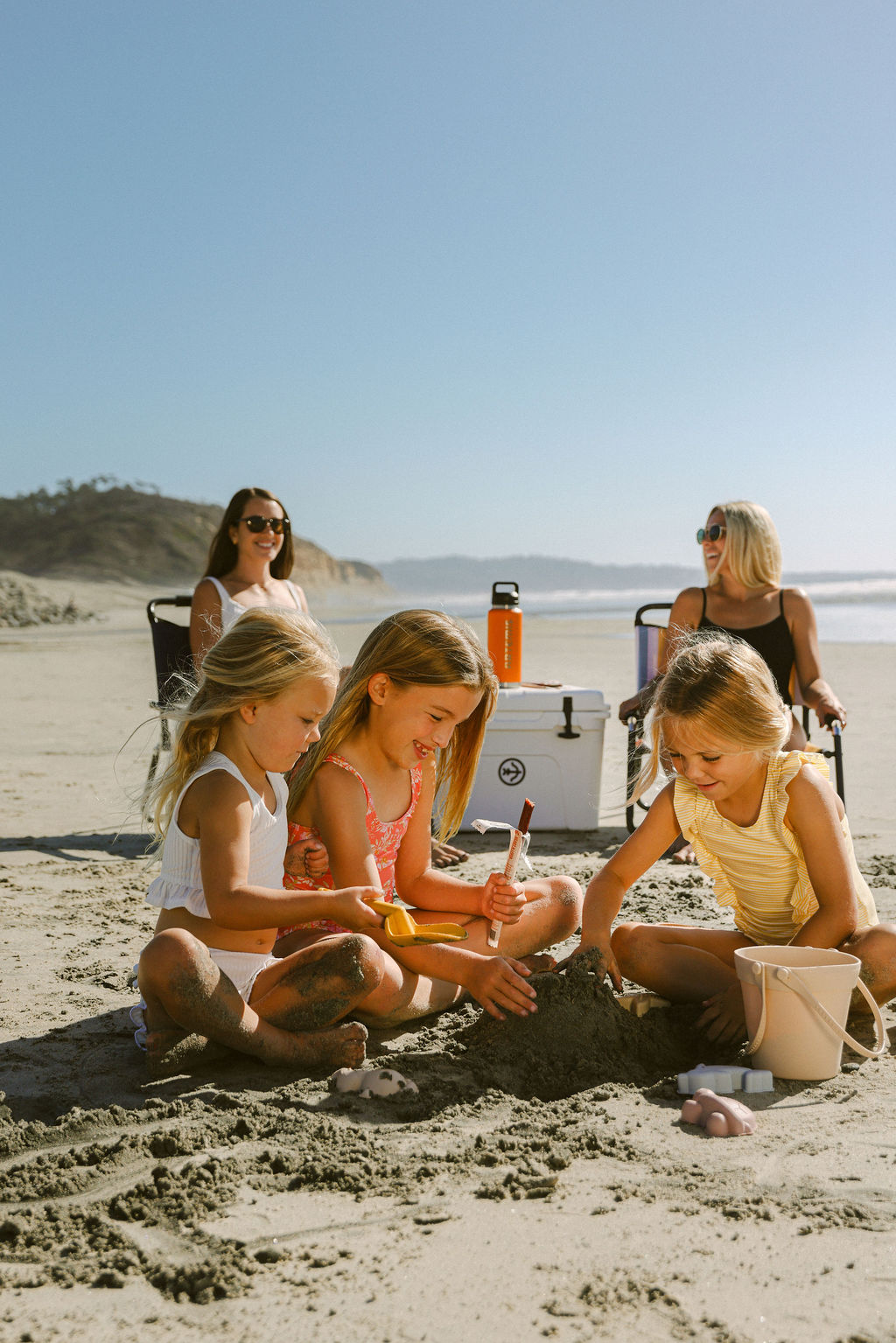 kids playing in sand at beach during family lifestyle brand photography for CPG company