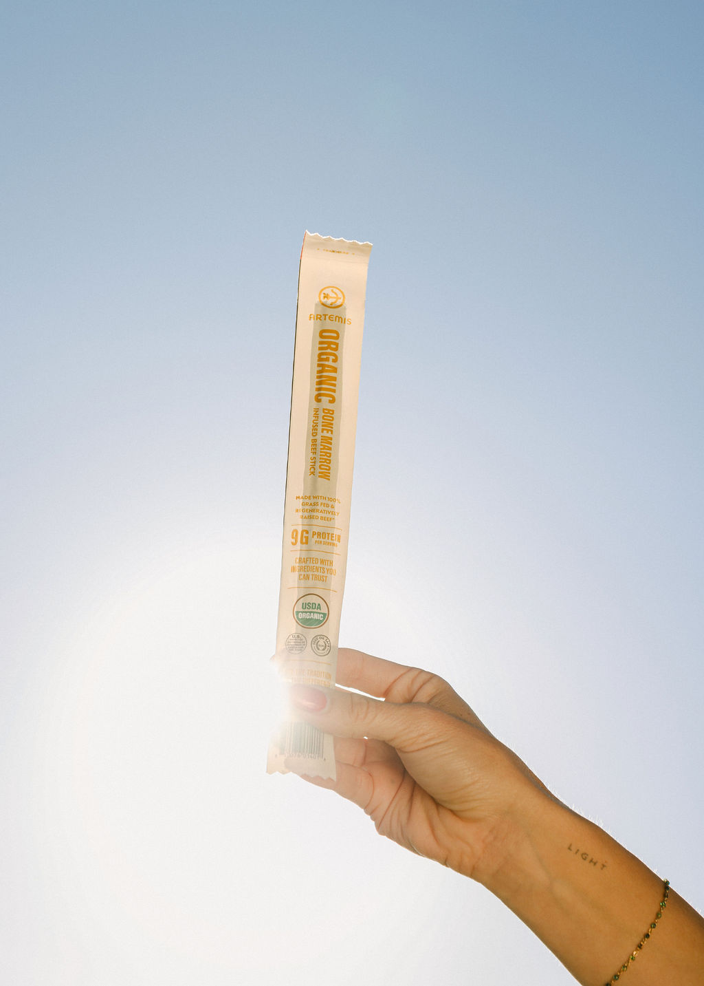 hands reaching for food product on beach blanket during lifestyle photography for CPG brand launch