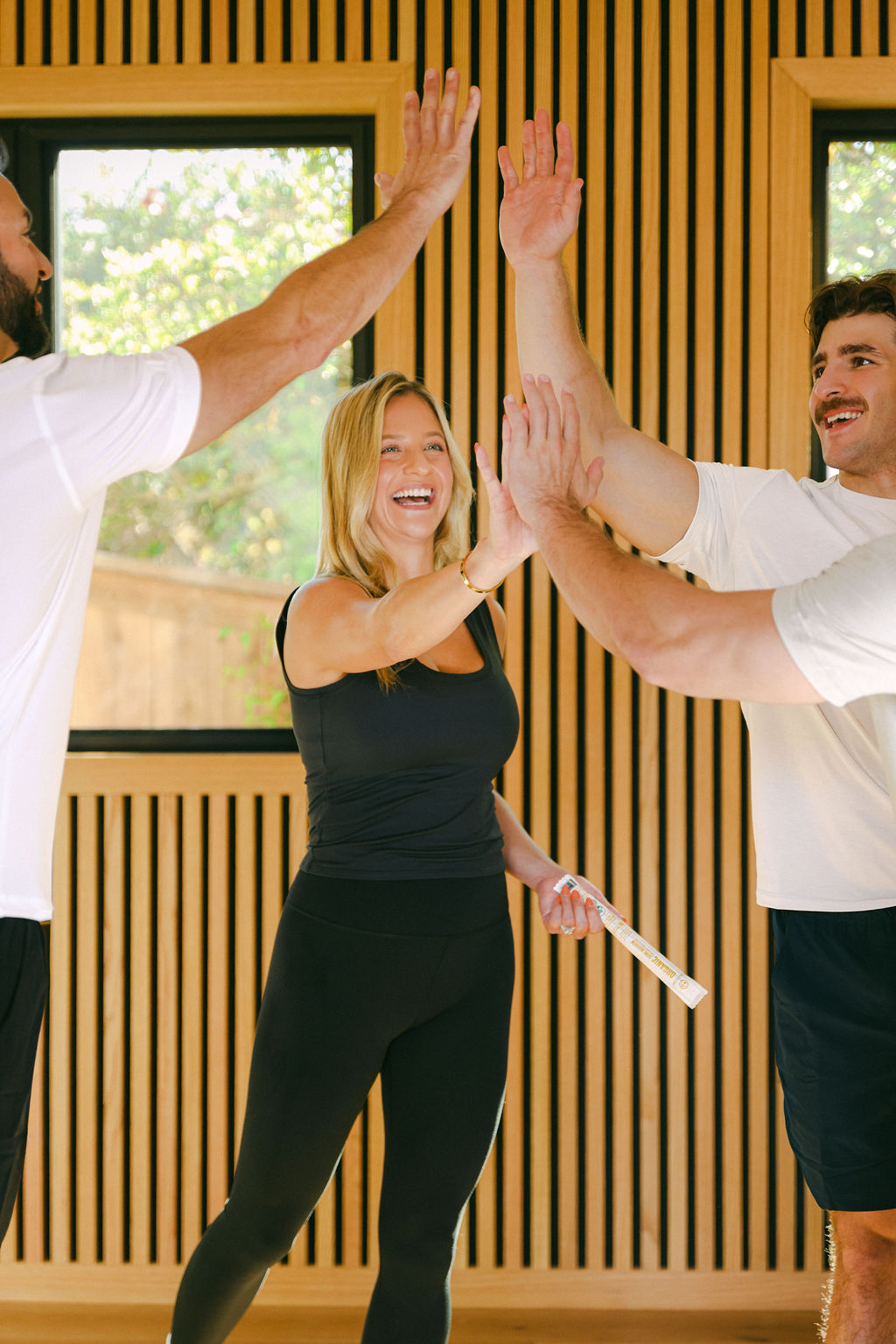 models celebrating after workout with high five during active lifestyle brand photoshoot