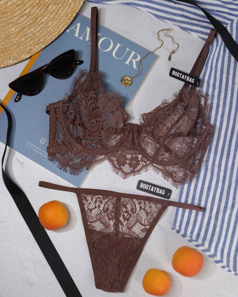 Bootay Bag chocolate lace lingerie flat lay styled on blue-striped linen with curated props