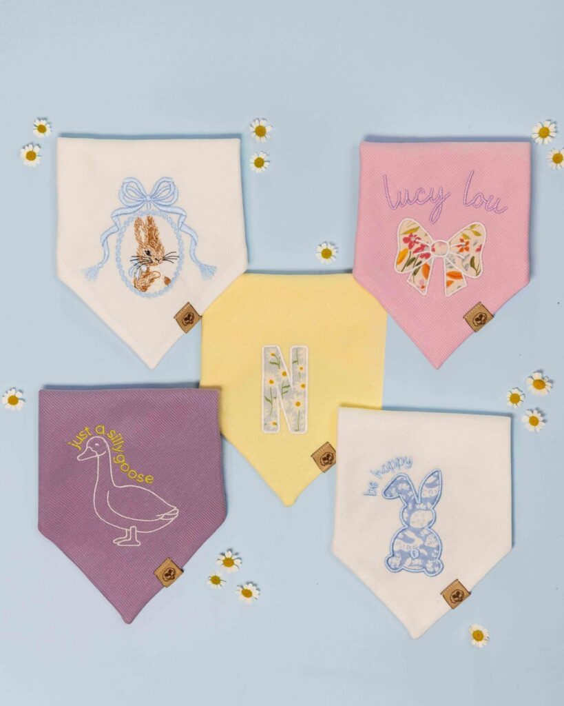 Cali Fluff Co spring pastel dog bandana flat lay with daisies on light blue background