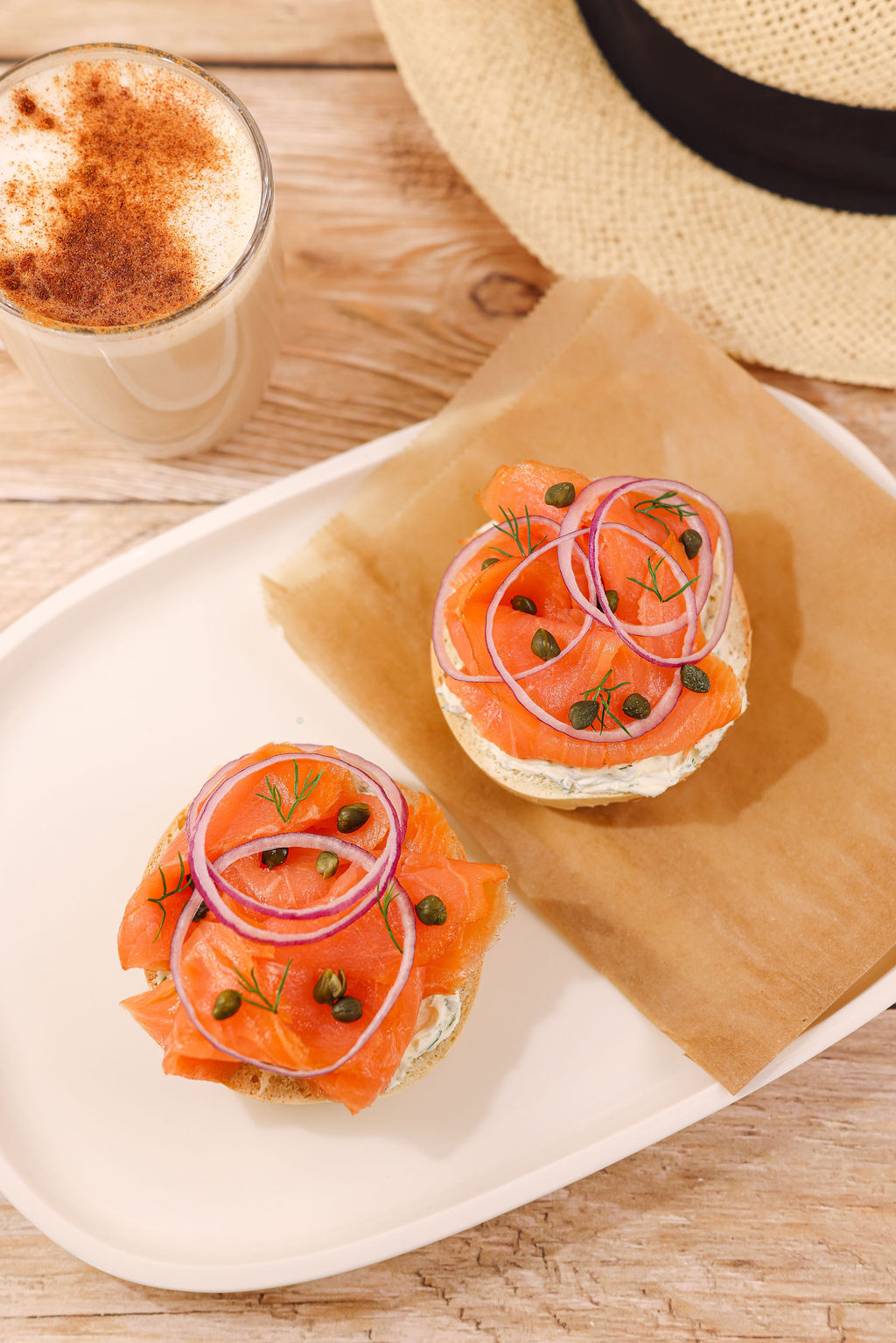 Styled salmon bagel breakfast sandwich on rustic wood cutting board for California hotel café menu photography
