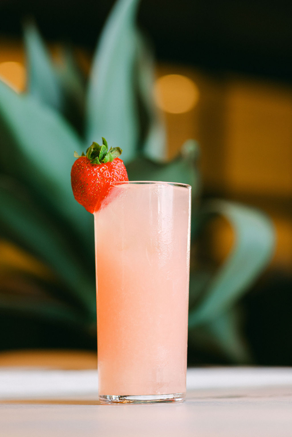 Styled pink cocktail with strawberry garnish for resort poolside bar menu photography by Chelsea Loren