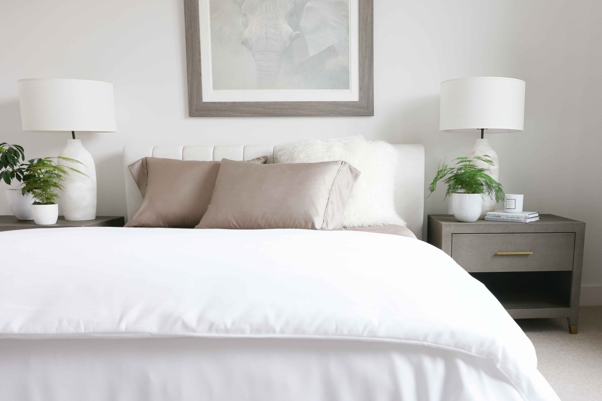 Styled bedroom featuring Jennifer Adams luxury bedding with intentional grey duvet drape and soft natural lighting