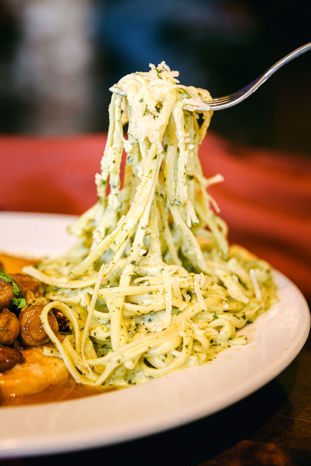 Fork-lift shot of herb pasta being dramatically lifted from bowl at Brickhouse Italian Restaurant in Lodi
