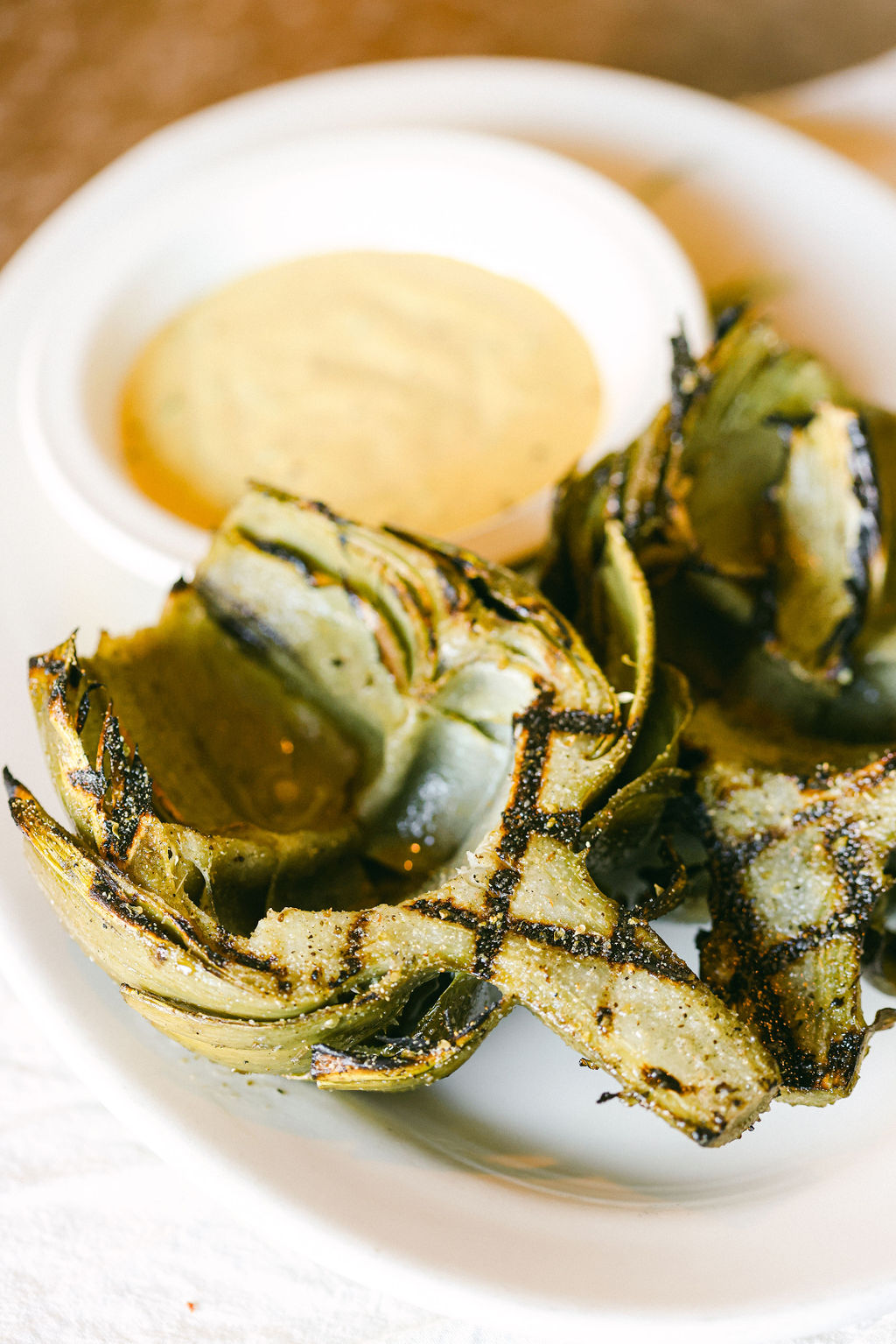 Grilled artichoke halves with charred edges and dipping sauce at Papapavlo's Mediterranean Bistro Lodi