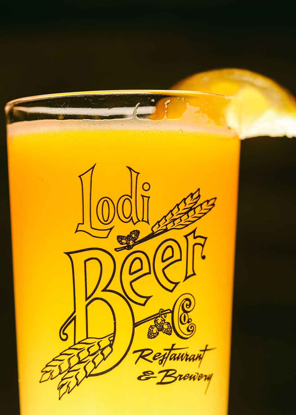 Espresso martini in coupe glass on wood shelf with warm bokeh red backdrop at Zin Bistro Lodi