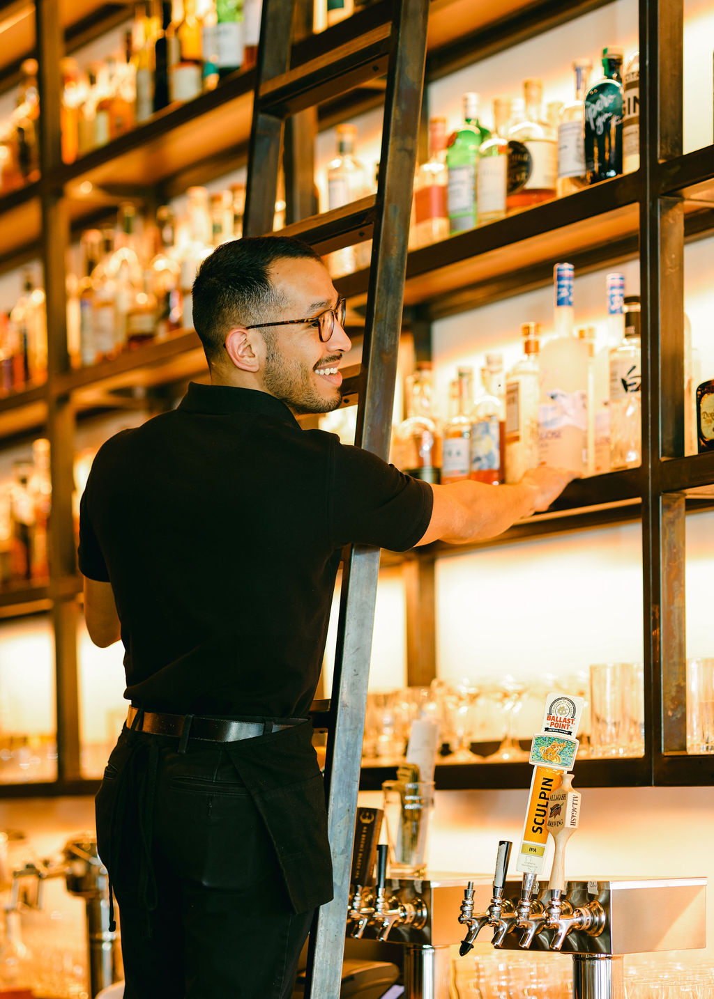 Old fashioned cocktail with cherry and orange peel in warm amber tones with red phone booth backdrop at The Oxford Kitchen Lodi